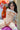 Sex doll with a realistic appearance in a room with flowers and a window.