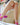 Person wearing pink socks with flower designs sitting on a couch.