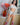 Person wearing a white top and floral knee-high socks in a room with flowers and a painting.