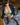 Sex doll wearing a black jacket, green bra, and stockings on a patterned rug.