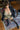 Sex doll wearing a black jacket, green bra, and stockings on a patterned rug.