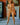 Naked person standing indoors with a painting in the background