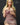 A highly realistic beige sex doll with long blonde hair, posed in a pink dress.