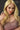 Close up of A highly realistic beige sex doll with long blonde hair, posed in a pink dress.
