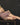 A highly realistic beige sex doll with long blonde hair, showing her boobs in a pink dress