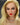 Close up of A highly realistic beige sex doll with long blonde hair.