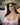The image shows a highly realistic sex doll with long brown hair.