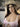 The image shows a highly realistic sex doll with long brown hair.