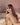 A nude doll showing boobs with siting on bed