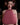 Person wearing a pink halter top and headphones in a dimly lit room.