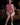Person wearing a pink outfit with matching headphones sitting on a brown couch.