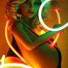Woman holding neon hoops with a warm glow