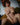 Naked person sitting on a couch in a room with a painting on the wall.