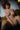 Naked person sitting on a couch in a room with a painting on the wall.