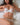 Woman wearing white lace lingerie on a bed