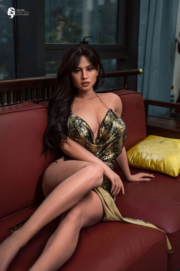 Woman in a gold dress sitting on a red couch with a blurred background