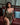 Woman in a gold dress sitting on a red couch with a blurred background