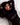 Woman in a black outfit lying on a white surface