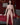 Sex doll standing in a bedroom setting with red curtains and a bed.