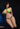 Model wearing a bright green bikini with black straps against a dark background