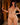 Model wearing a gold lingerie set with a blurred background