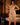 Woman in gold lingerie standing in a bedroom setting