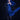 Person in a blue dress with long hair and black gloves against a dark background