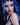 Person with blue hair and dark makeup wearing a black glove