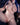 Partial nude figure with blue hair and a necklace against a dark background