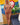 Naked person standing in a room with a colorful wall painting and a blue couch.