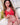 Person wearing a red outfit with a white cross on a white couch.