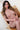 Naked person sitting on a wooden chair with a white background