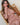 Person sitting on a wooden chair with a neutral background