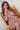 Person sitting on a wooden chair with a neutral background