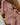 Partial nude image of a person sitting on a chair.