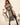 Woman in a costume holding a sword on a neutral background