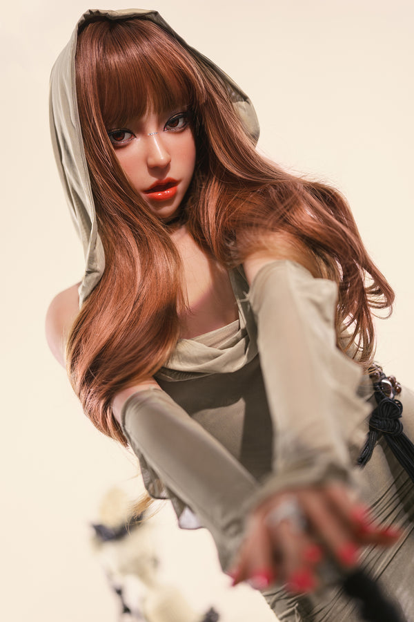 Person with long brown hair and red lipstick wearing a light-colored outfit.