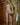 Sex doll in a bathroom setting with bottles on a shelf.