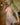 Sex doll with blonde hair and red lipstick on a wooden floor.