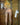 Person standing in a shower with tiled walls and a towel rack.