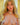 Realistic silicone doll with blonde hair and green eyes against a neutral background