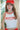 Person wearing a red cap and 'Boston 1998' tank top with blurred background