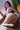 A sex doll with violet hair showing her body while laying.