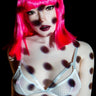 Person with pink hair and polka dot body paint wearing a white bra against a black background