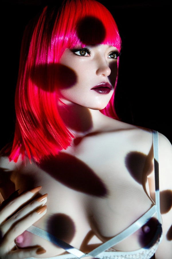 Person with bright pink hair and polka dot pattern on a dark background