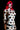 Person with red hair and polka dot body paint against a black background