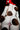 Person wearing a cow print outfit with a red hood on a black background