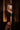 Woman in a black dress with sheer panels in a dimly lit room