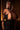 Person wearing a black dress with a deep neckline in a dimly lit setting