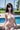 Woman in a white bikini standing by a pool with a scenic background